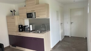 A compact kitchen with a microwave, toaster, and sink.