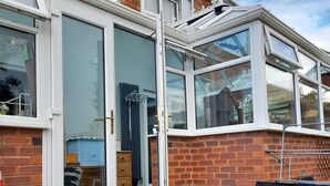 Un immeuble résidentiel à la façade en briques, doté de grandes fenêtres et d’un patio couvert.