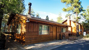 A rustic wooden cabin with a chimney, large windows, and a porch. - Cubs Nest (Sugarloaf)