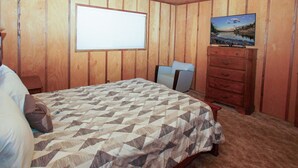 A bedroom with a bed, a dresser, a chair, and a painting on the wall. - Cubs Nest (Sugarloaf)