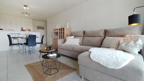 Ein modernes Wohnzimmer mit Sofa, Couchtisch und Essbereich.