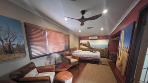 Um quarto espaçoso com cama, sofá, mesa de centro e tapete.