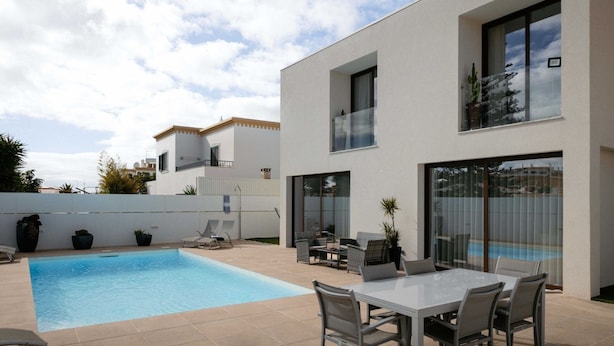 A modern house with a swimming pool, outdoor seating, and large windows. - Comfortable Villa Algarve for up to 10 guests (Alcantarilha)