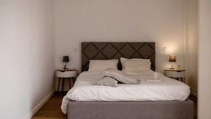 A neatly made bed with a headboard, two bedside tables with lamps, and a bench at the foot of the bed. - Comfortable Villa Algarve for up to 10 guests (Alcantarilha)