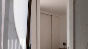 A room with a sliding door, a small table with a lamp, and a closet with sliding doors. - Comfortable Villa Algarve for up to 10 guests (Alcantarilha)