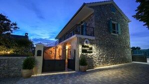 A stone building with a balcony and a sign reading "Božini dvor". - Amazing home in Gornje Rastane with sauna (Gornje Rastane)