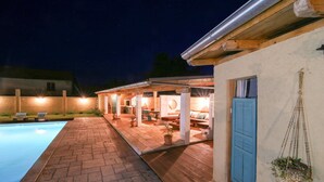 A poolside area with a covered patio, outdoor seating, and a blue door. - Amazing home in Gornje Rastane with sauna (Gornje Rastane)