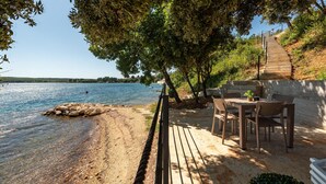 A wooden deck with outdoor seating overlooking a lake. - Awesome home in Posedarje (Posedarje)