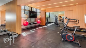 A modern gym with exercise equipment, a treadmill, and a mirrored wall. - Maison Perdizes – Allianz Parque Supreme (Sao Paulo)