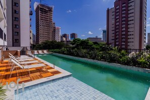 A rooftop pool with lounge chairs and a view of surrounding high-rise buildings. - Maison Perdizes – Allianz Parque Supreme (Sao Paulo)