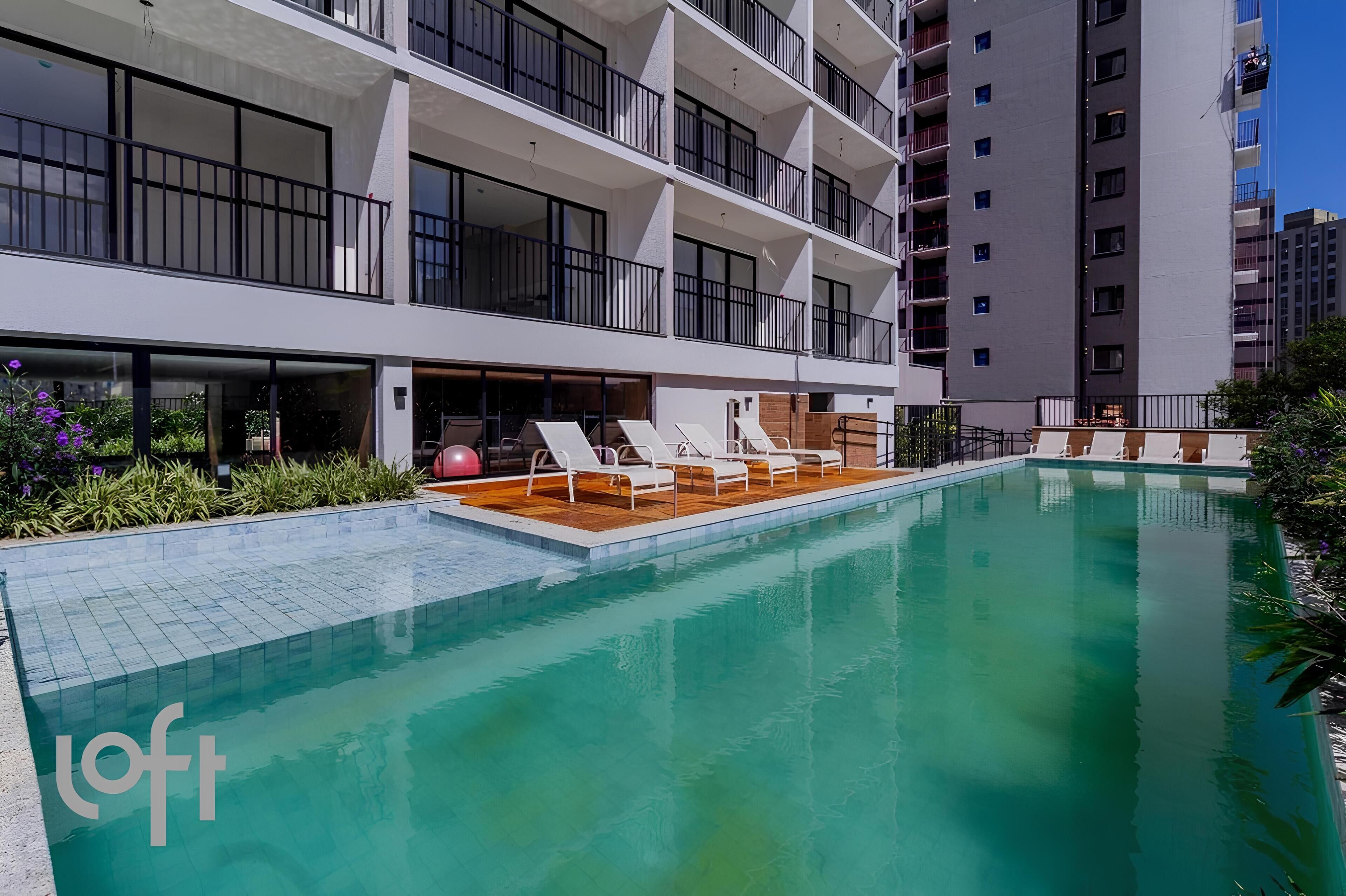A modern hotel with a swimming pool, multiple balconies, and a well-maintained garden area.