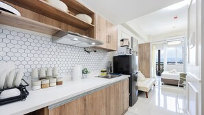 Una cocina moderna con armarios de madera, encimera blanca y salpicadero con mosaicos hexagonales.