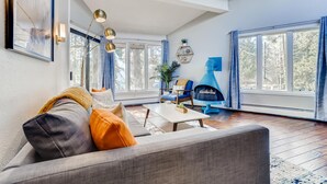 A modern living room with a sofa, coffee table, and a blue fireplace.