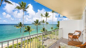A balcony with a view of the ocean and palm trees. - Beachfront Condo with Beach Access (Hauula)