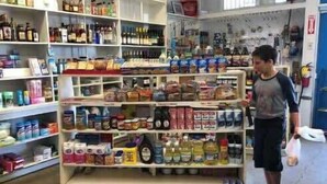 Un magasin dont les étagères sont remplies de divers produits alimentaires et boissons.