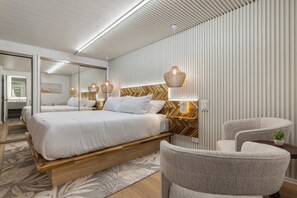 A modern bedroom with a large bed, bedside lamps, and a herringbone-patterned headboard.