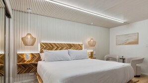 Ein modernes Schlafzimmer mit einem großen Bett, einem Holzkopfteil und zwei Wandlampen.