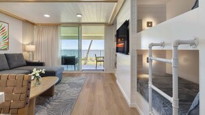 Ein modernes Zimmer mit einer Couch, einem Holztisch, einem Etagenbett und einem Balkon mit Blick.