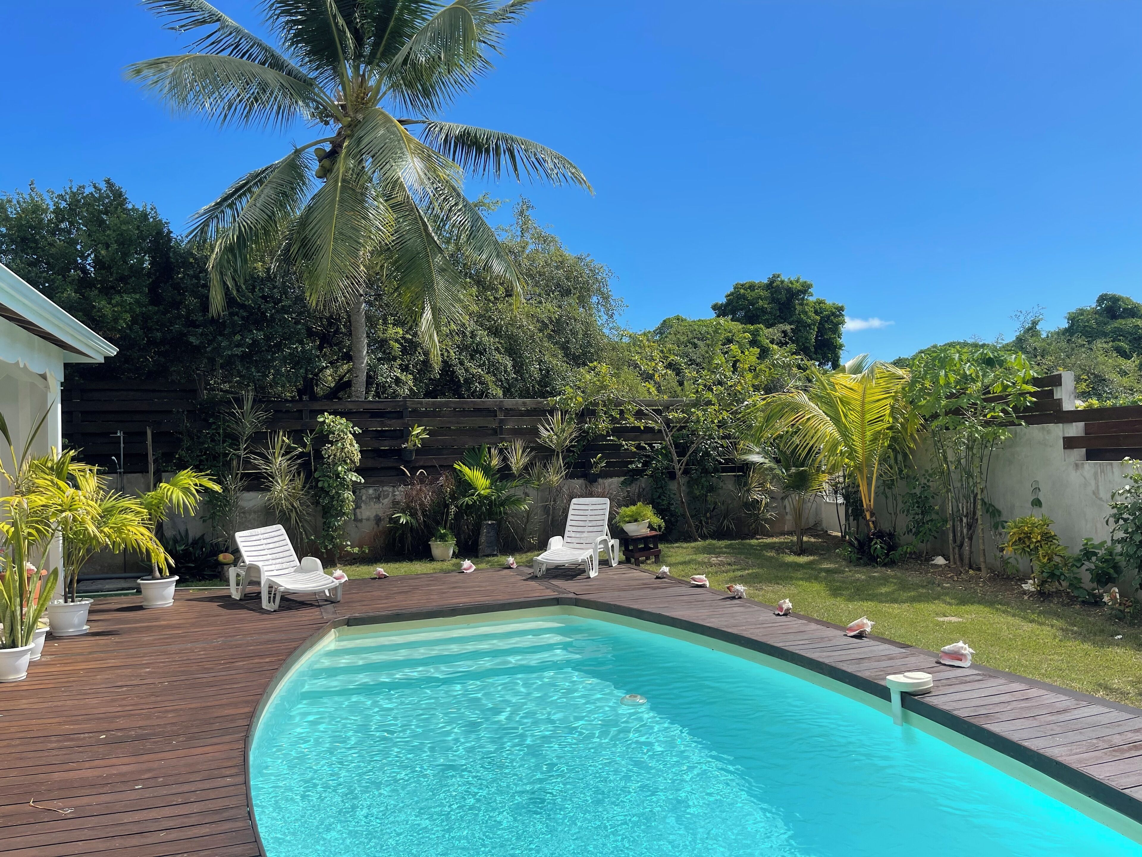 Ein Swimmingpool mit weißen Liegestühlen und einer Holzterrasse.