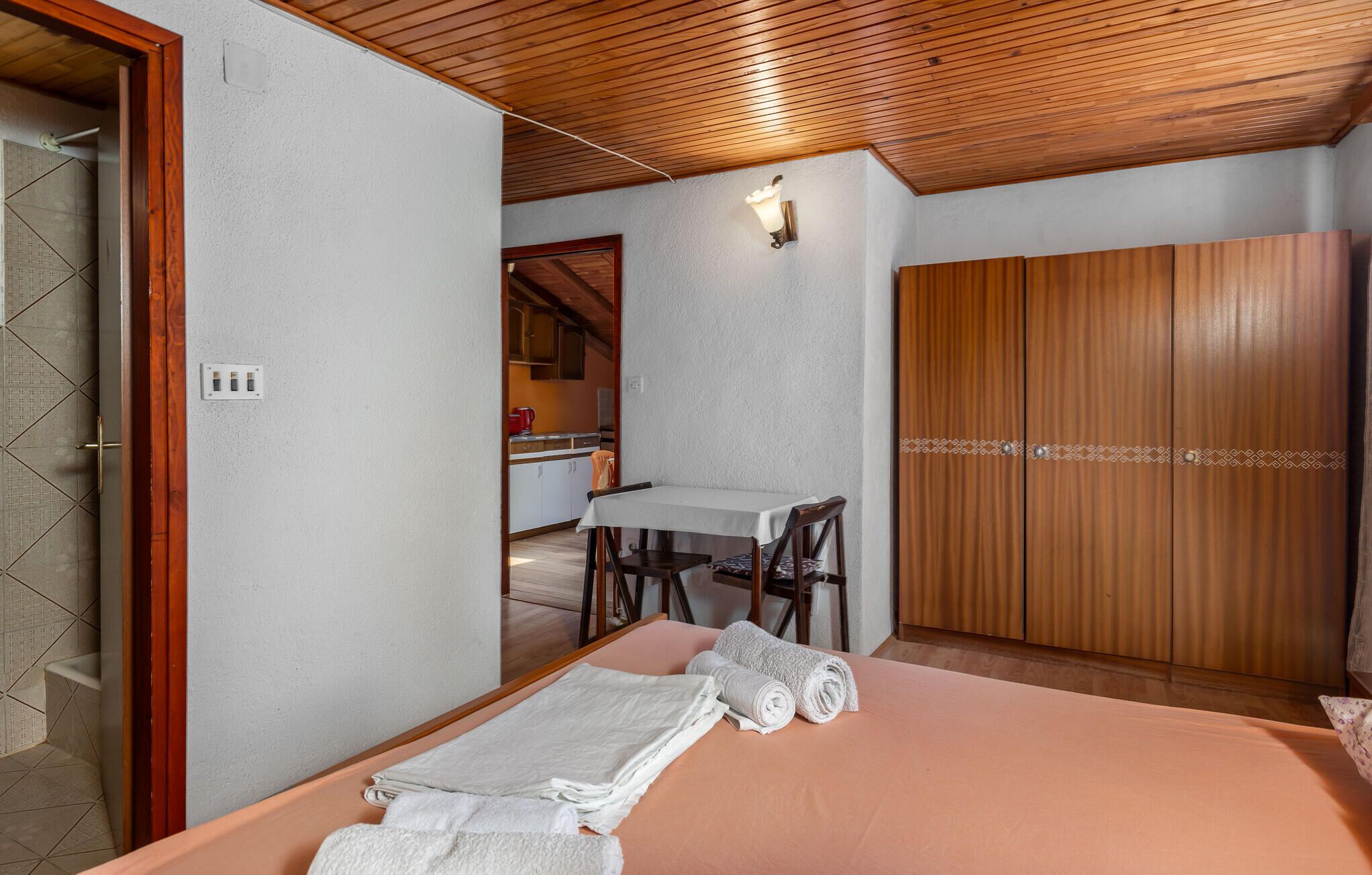 Una camera da letto con un letto, un tavolo e un armadio.