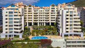 A multi-story hotel with balconies, a swimming pool, and landscaped gardens. - Arcadas III – Comfort and Sea View in Funchal (São Martinho)