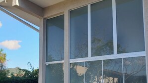 A building with large windows, a concrete exterior, and a visible door.