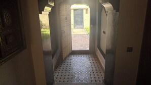 Un pasillo con piso de baldosas que conduce a una puerta abierta.
