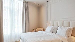 Un dormitorio con una cama grande, una mesita de noche y una lámpara.