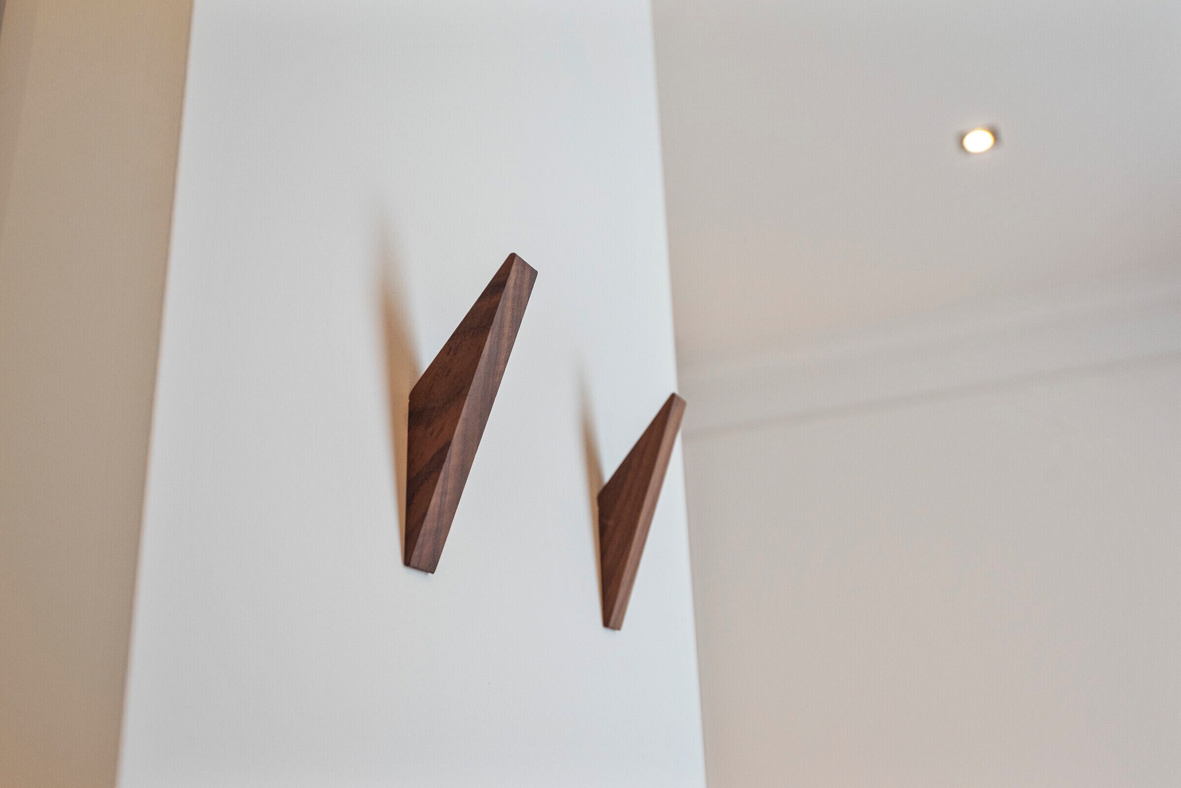 A white wall with two wooden wall-mounted light fixtures.