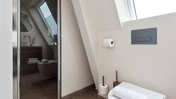 Ein modernes Badezimmer mit Duschkabine aus Glas, Toilette und Waschbecken.