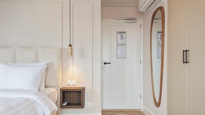 Un dormitorio con cama, mesita de noche y espejo.