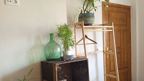 Ein Zimmer mit einer Holzladelei, einem kleinen Tisch mit einer Vase und Pflanze sowie einem gemusterten Teppich.