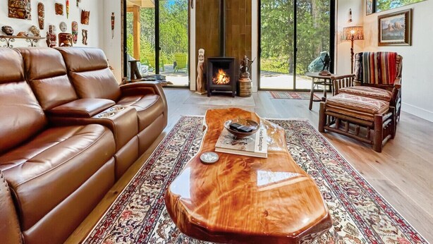 Ein geräumiges Wohnzimmer mit einer Ledersofa, einem Holztisch und einem Kamin.