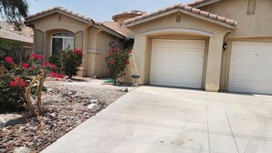 A residential house with a driveway, garage, and landscaping.