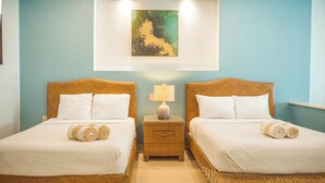 Une chambre d’hôtel avec deux lits, une table de chevet avec une lampe et un tableau au mur.
