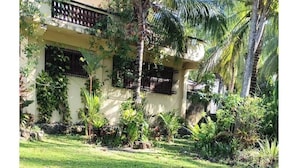 A building with a flat roof, surrounded by a well-maintained lawn and palm trees.