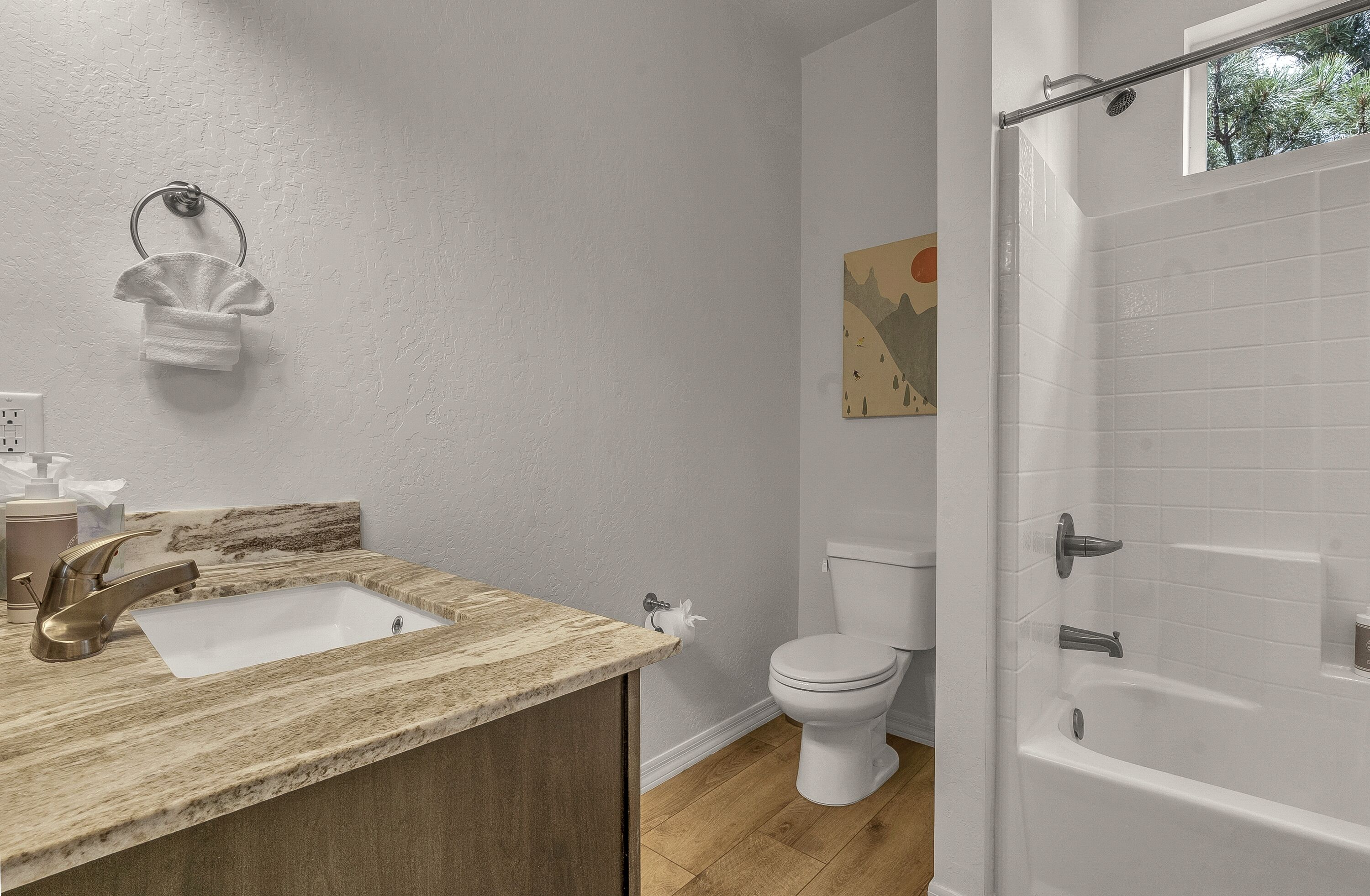 Ein Badezimmer mit Marmorwaschbecken, Toilette und Badewanne.