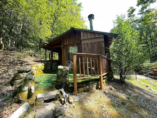 A rustic wooden cabin with a stone water feature in front. - Oak Shores Oasis on Lake Ouachita! (Mount Ida)
