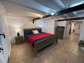 A bedroom with a bed, bedside tables, a dresser, and a window. - Oak Shores Oasis on Lake Ouachita! (Mount Ida)