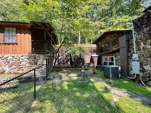 Eine rustikale Holzhütte mit Steinwand, einer Holzdiele und einer Klimaanlage.