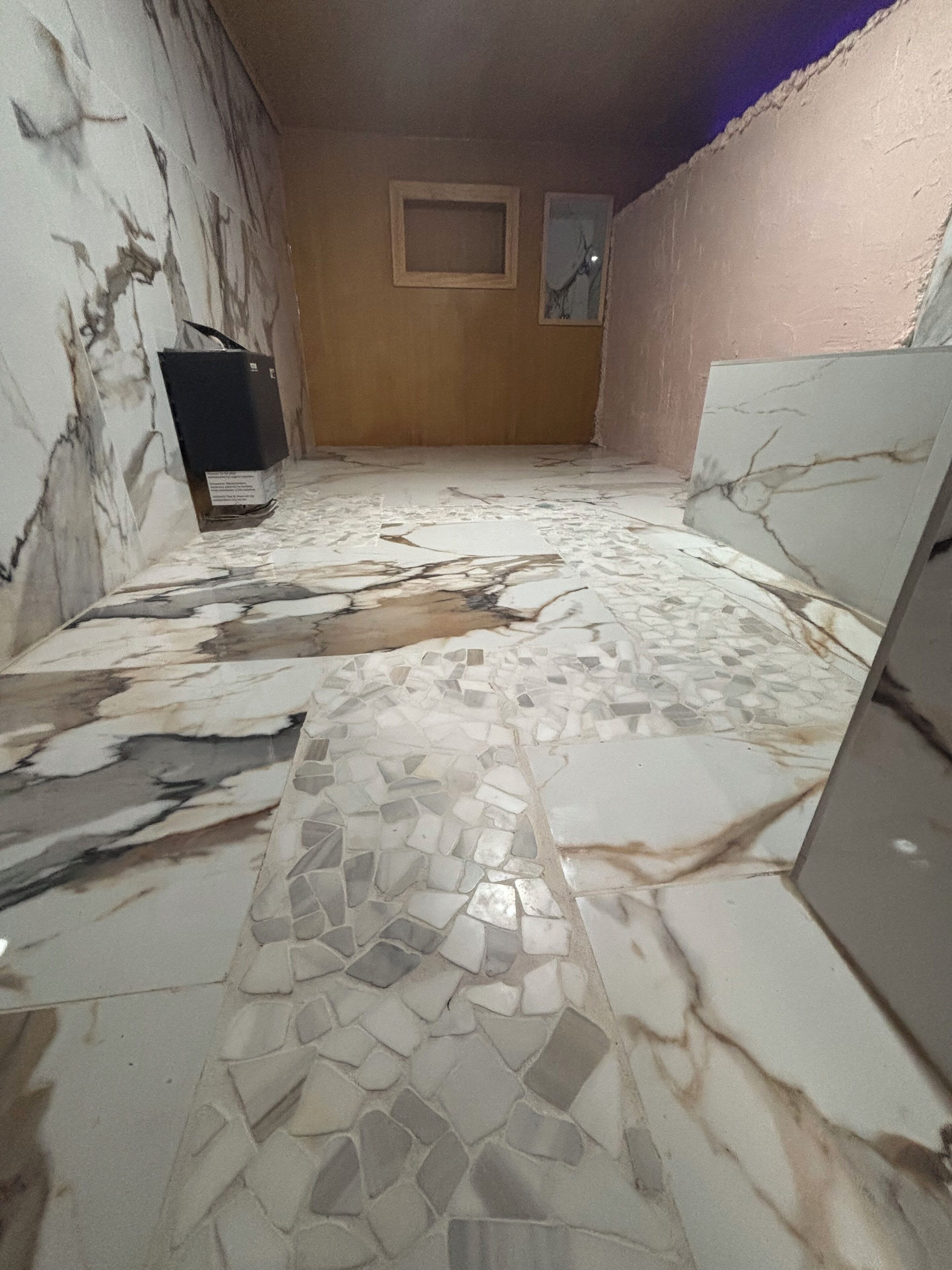 A room with a tiled floor featuring a mix of marble and mosaic patterns.