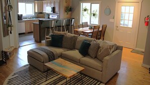 Ein Wohnzimmer mit einer Couch, einem Couchtisch und einem Essbereich mit Stühlen und einem Tisch.