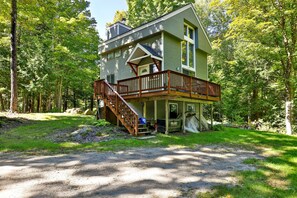 A two-story house with a wooden deck and a staircase leading to the second floor. - Bob's Sled Lodge – 2BR Killington Retreat Near Slopes & Trails (Killington)