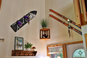 Una habitación con decoración temática de esquí, que incluye un cuadro enmarcado y esquíes montados.