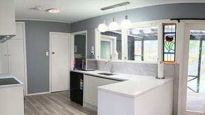 Una cocina moderna con armarios blancos, microondas integrado y una isla grande.