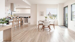 Una cocina moderna con comedor, piso de madera y un ventanal con vista a la ciudad.