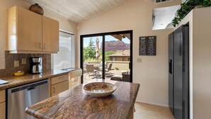 Una cocina moderna con una isla grande, electrodomésticos integrados y vistas al exterior.