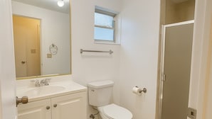 A bathroom with a toilet, sink, mirror, and a window. - Modern Studio in the Heart of Wynwood (Miami)