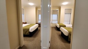 Een hotelkamer met twee bedden, een bureau en een raam.