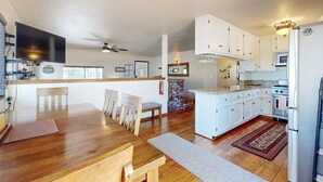 Una cocina amplia con armarios blancos, una isla grande y un horno empotrado.